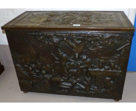 A large continental brass log box with extensive floral relief decoration, the front panel depicting a tavern scene