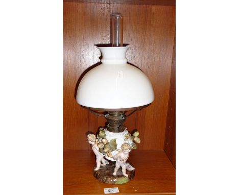 19th c. German porcelain oil lamp with cherubs and chestnuts decoration around reservoir base, having crossed swords mark to 