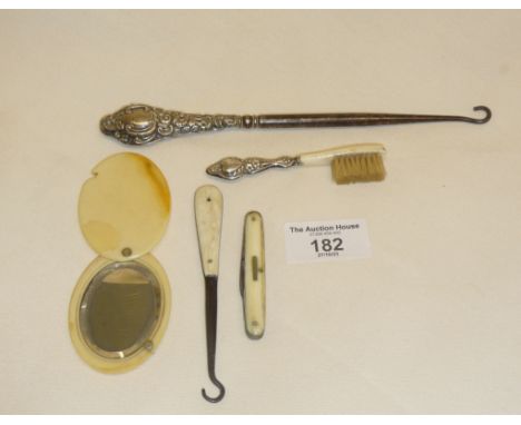 Button hooks, one with silver handle, small silver-handled brush, a fruit knife and a celluloid pocket or purse mirror