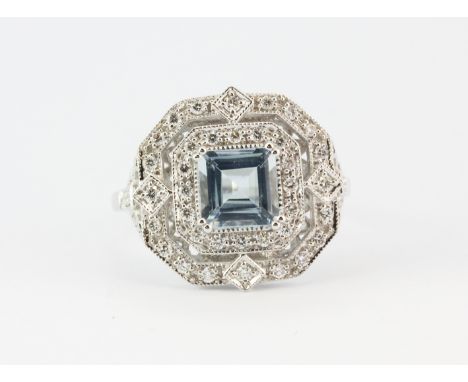 An Art Deco style 18ct white gold ring set with a centre aquamarine surrounded by two rows of brilliant cut diamonds, (N).