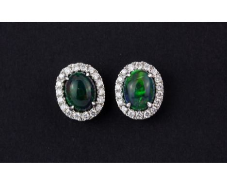 A pair of 18ct white gold cluster earrings set with a cabochon cut black opal, approx. 1.79ct overall, surrounded by diamonds