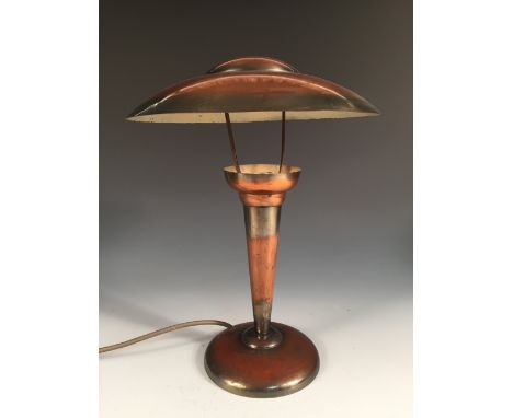 An Art Deco copper table lamp, the domed shade above a tapering cylindrical column and spreading circular foot 36cm (14in)  