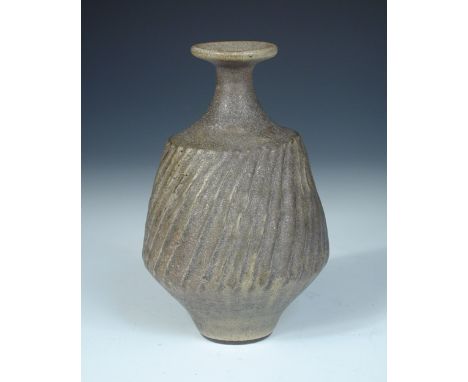 § Dame Lucie Rie (Austrian, 1902-1995), a rare dolomite glaze vase, the compressed bottle form with wrythen fluted body and s