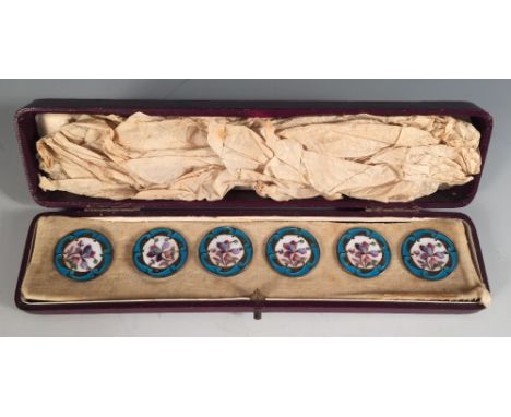 A cased set of six metalwares and enamel buttons, each enamelled with floral motif and turquoise borders  