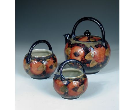 An unusual Moorcroft Pomegranate pattern three-piece tea set, comprising teapot, sugar basin and milk jug, all of globular fo