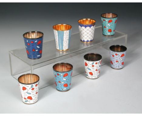 Eight mid 20th century enamel tot cups, variously enamelled in colours, comprising two gilt cups, the others in white base me