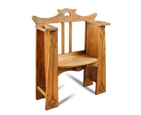 An Arts and Crafts oak hall seat, the shaped back with pierced heart motif above a shaped seat, each side with integral stick