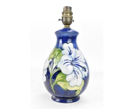 A Moorcroft pottery 'Hibiscus' pattern table lamp, of baluster form, tube lined decorated with flowers on a blue ground, sign