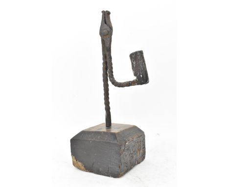 An 18th century wrought iron rush-light holder, with a candle socket arm raised on an oak base, 26cm high 