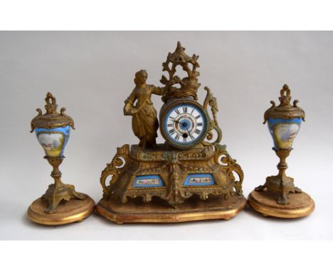 A European brass and enamel faced clock with associated garnitures
