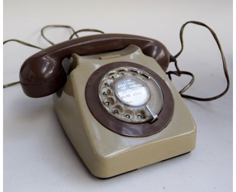 A vintage rotary telephone in brown and green, with stickers to base one reading 'Tele 8746 G B.T. Q.C Batch Sampled FWG 84/1