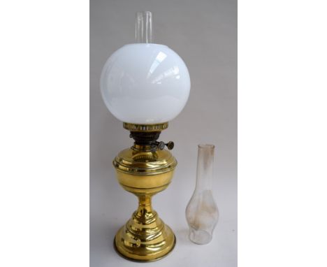 A late 19th century brass mounted oil lamp, complete with glass shade and two chimneys, height 55cmH including chimney