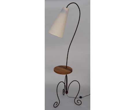 A modern French standard lamp with conical shade and bent metal stand with wooden shelf, 191cmH
