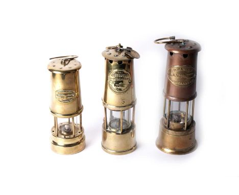 Three brass miners’ lamps: an Eccles ‘The Protector’, 27cms, with three pit checks; a Ferndale Coal and Mining Co, 23cms; and