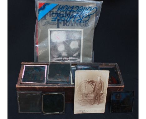 A collection of magic lantern slides and a Penny Farthing postcard.