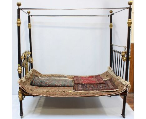A Victorian brass and black-painted iron four-poster bed, with wooden-slatted mattress base, 124cm wide.  