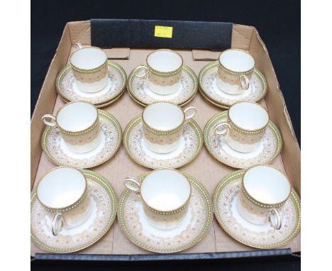 A set of nine Royal Worcester jewelled coffee cans and saucers, c.1916, with gilt decoration and green banding, with three ad