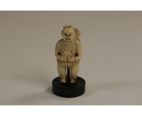 Carved ivory Netsuke of a figure carrying a lotus flower over  his shoulder, Japan ca. 1900-1920, h. 5.5 cm.  The item comes 