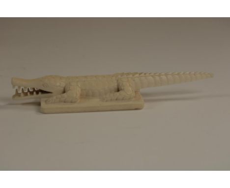 Carved ivory sculpture of a crocodile standing on a rectangular  base, Africa ca. 1920-1940, h. 3, w. 19.5 cm.   The item com