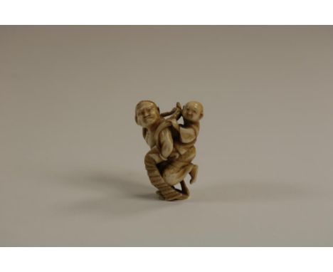 Carved ivory Netsuke of a man with a child on his back, Japan ca.  1900, h. 5 cm.  The item comes with a certificate of authe