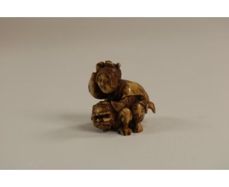 Carved ivory Netsuke, shaped as a lady riding a temple lion,  Japan ca. 1900, h. 3, w. 3.5, d. 3 cm.   The item comes with a 