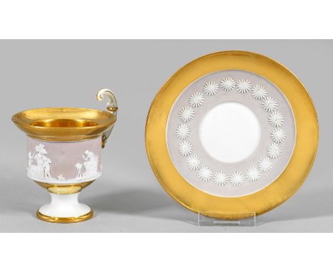 Prächtige Biedermeier-Ziertasse mit Relieffriesauf Untertasse. Biskuitporzellan, teilw. glasiert. Glockenbecherform mit hochg