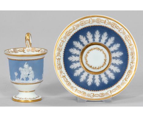 Prächtige Biedermeier-Ziertasse mit Relieffriesmit Untertasse. Glockenbecherförmiger Korpus mit hochgezogenem Volutenhenkel. 