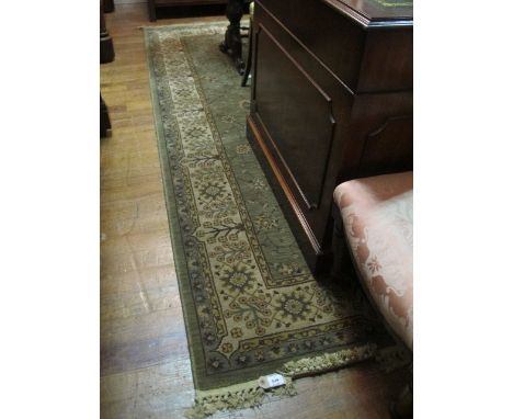 A WOOL RUG the light green and beige ground with overall floral pattern within a conforming border 140cm x 200cm