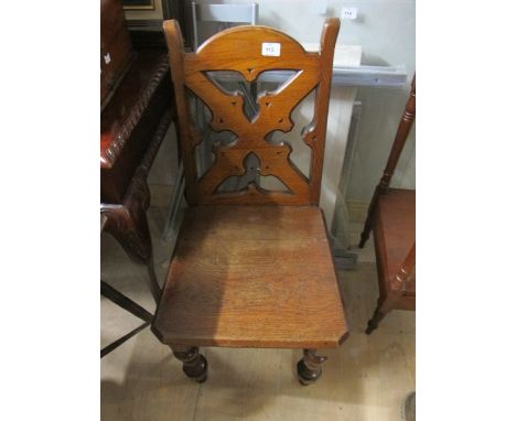 AN OAK GOTHIC STYLE HALL CHAIR with pierced Gothic tracery back and panel seat on turned legs