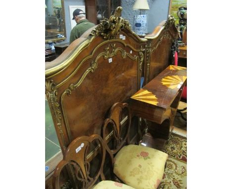 A PAIR OF CONTINENTAL WALNUT AND PARCEL GILT HEADBOARDS each with a serpentine top rail with foliate and flowerhead carving a