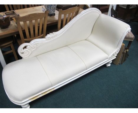 A VICTORIAN STYLE WHITE PAINTED CHAISE LONGUE the carved top rail with upholstered panel and seat with carved arm support on 