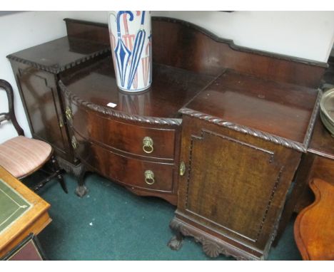 A CHIPPENDALE STYLE MAHOGANY SIDEBOARD of rectangular bowed outline with two frieze drawers and cupboards with brass lion mas