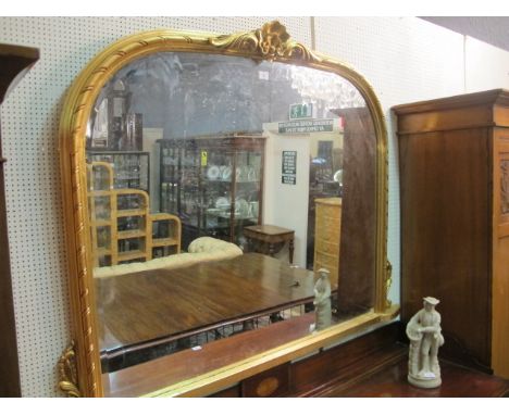 A GILT ARCHED OVERMANTEL MIRROR with bevelled glass and moulded surround with central shelf 128cm (h) x 155cm (w)