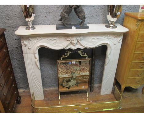 AN ART DECO STYLE WHITE MARBLE CHIMNEY PIECE the serpentine moulded shelf above a figural carved frieze raised on carved flow