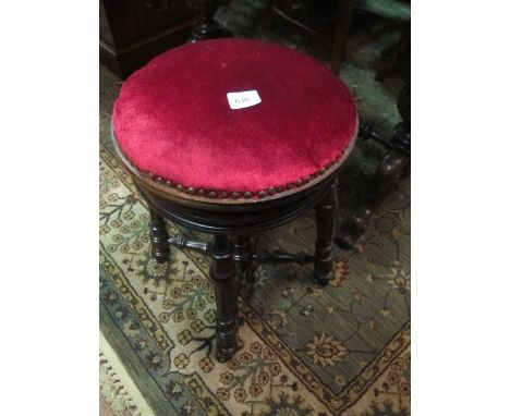 AN EDWARDIAN MAHOGANY REVOLVING STOOL the circular upholstered seat on reeded and ring turned legs joined by baluster stretch