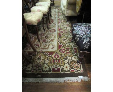 A WOOL RUG the light brown and beige ground with central floral panel within a conforming border 350cm x 250cm
