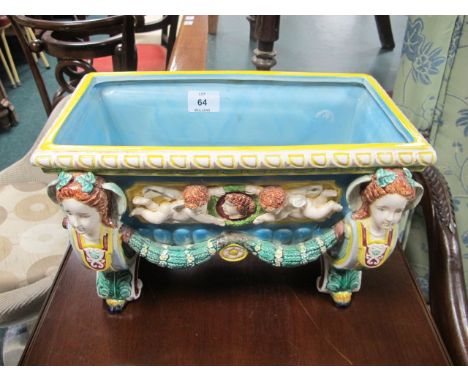 A MAJOLICA PLANTER of rectangular form the light blue, green and yellow ground with figural masks moulded in relief with wing