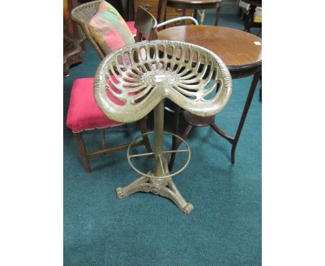 A CAST IRON SWIVEL TOP STOOL modelled after a tractor seat