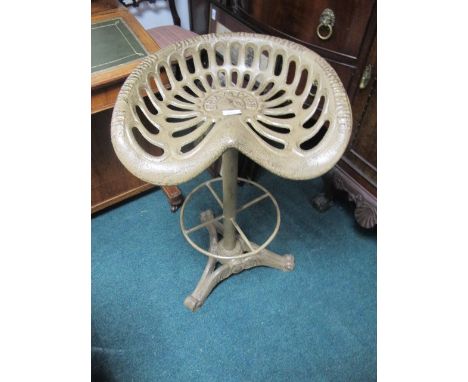 A CAST IRON STOOL modelled after a tractor seat on tripod base