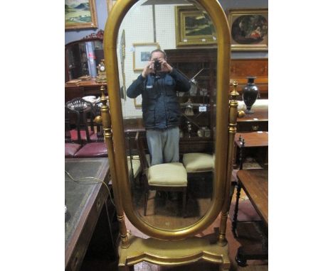 A CONTINENTAL GILT FRAME CHEVAL MIRROR the oval bevelled glass plate within a moulded frame on ring turned supports and platf