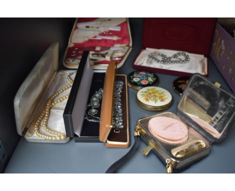 A mixed lot of vintage compacts including Stratton, costume jewellery and a manicure set. Also included is a small black even