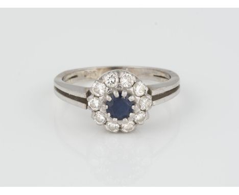 RING Weißgold. Ringmaß ca. 54, Ges.-Gew. ca. 4 g. Gest. 585. Ein rund facettierter Saphir, ca. 0,35 ct., 10 Brillanten, zusam
