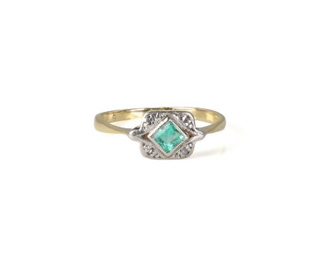 An Art Deco emerald and diamond plaque ring,  with a square step cut emerald, millegrain set to the centre. Marked 18. 1.46g.