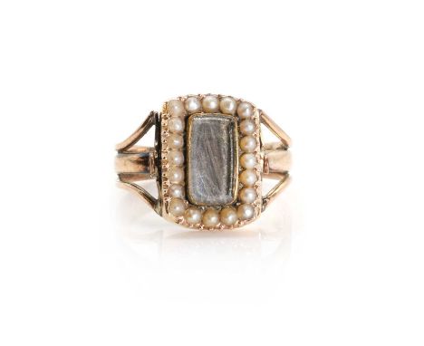 A Georgian mourning ring, c.1807, of swivel panel form, the front with a glazed panel within a surround of split pearls to a 