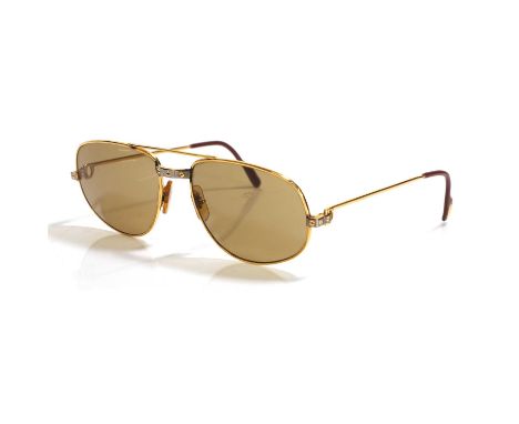 A pair of vintage Cartier sunglasses, 1986, Cartier Romance Santos, gold tone frame with brown tinted lens, engraved 1986 Car