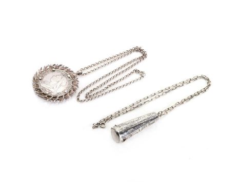 Two silver necklaces, including a silver pill box, with decorative engraving across it, suspended from a silver paperclip cha