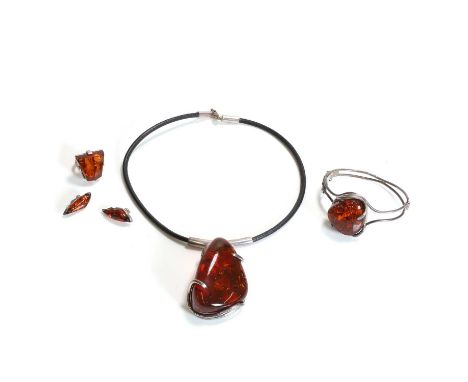 A group of silver amber jewellery, comprising an amber hinged bangle, stamped 925, a pair of amber clip earrings, an amber ri