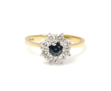 An 18ct gold sapphire and diamond cluster ring,  with a round cut sapphire, to a surround of round brilliant cut diamonds, al