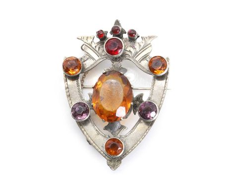 A Victorian shield form paste brooch, with oval and round cut red orange and purple paste, to a hollow hand engraved shield s