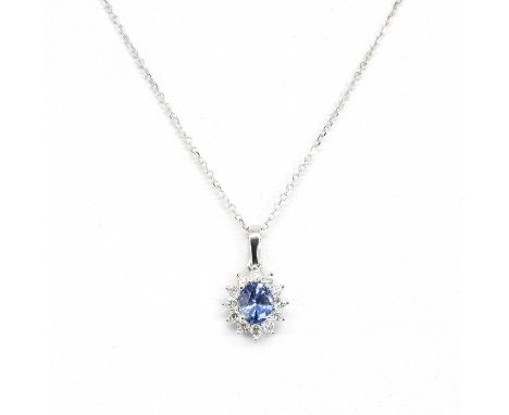 An 18ct white gold sapphire and diamond pendant and chain, with an oval mixed cut sapphire, with a stated weight of 0.79ct, c